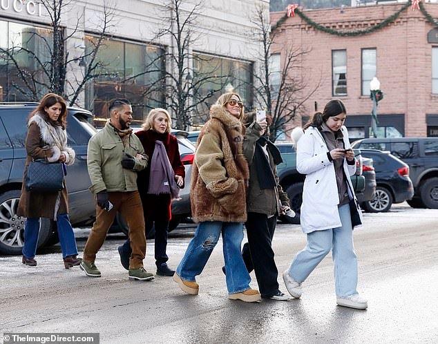 Lynda complemented J.Lo with a brown leather jacket featuring voluminous gray fur trim on the collar and cuffs, and Emme rocked a gray denim jacket with a white hoodie and dark jeans