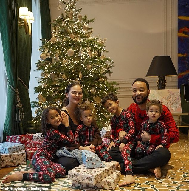 John Legend and Chrissy Teigen gathered round the tree on Christmas morning with their children Luna, eight, Miles, six, Esti, one, and Wren, one