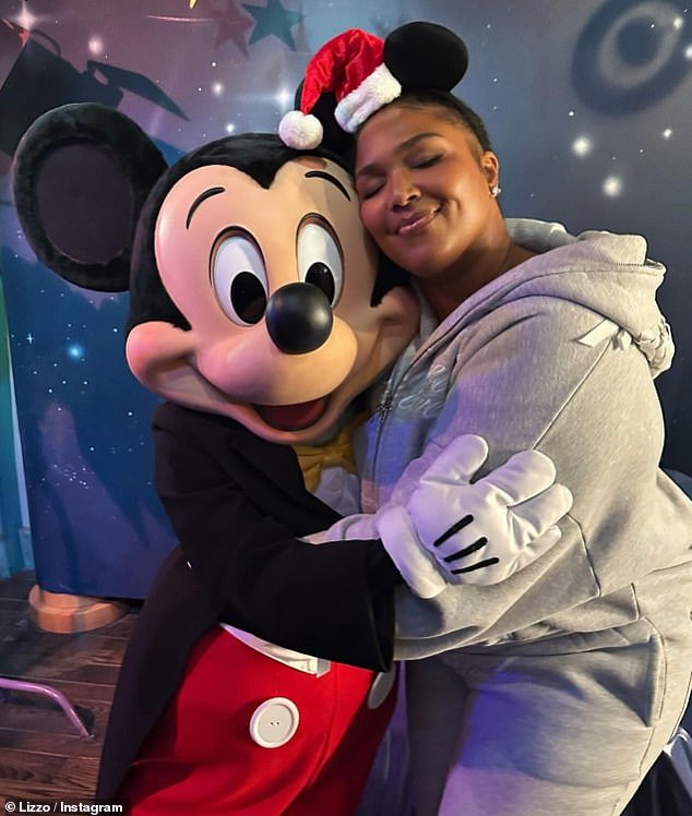 Lizzo enjoyed a hug from someone dressed as Mickey Mouse, and threw herself into the spirit of the occasion by wearing her own set of Mickey ears with a Santa hat