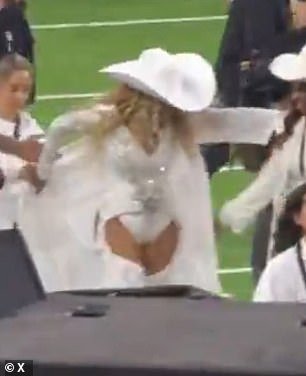 The celebrity was so overwhelmed with emotion that she struggled to put on her white coat after heading off the football field