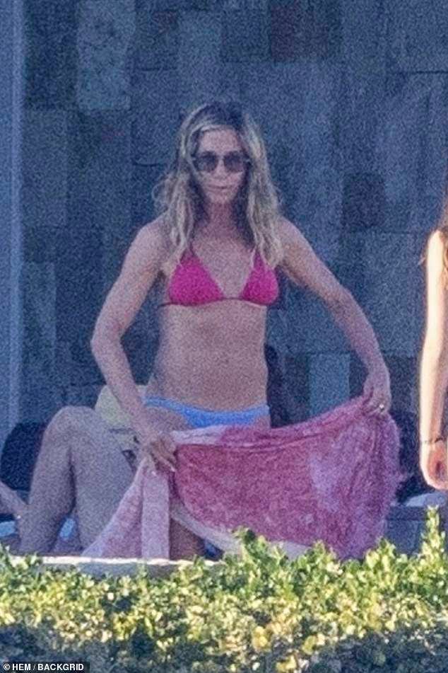 Aniston was seen taking off her sarong to reveal her toned physique