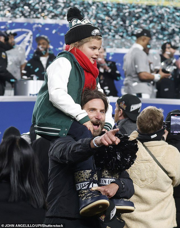 The father-daughter duo, both decked out in green Eagles gear, flashed bright smiles as they went down to the field to celebrate the team's victory