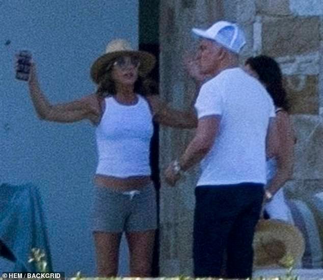 Aniston was later seen chatting with pals while rocking a skintight white tank top and low-slung gray shorts