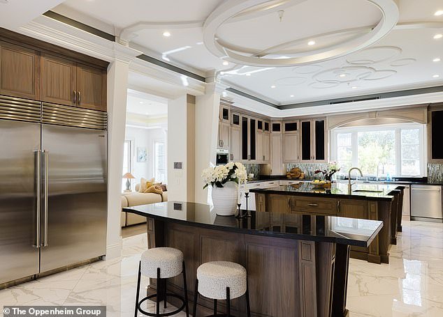 The kitchen has modern appliances as well as two islands in the middle and wooden cabinetry