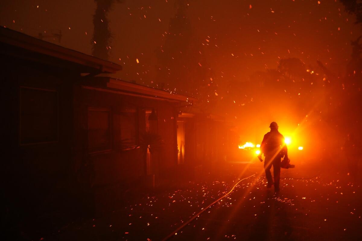 A firefighter walks towards his engine after trying to prevent the Woolsey fire.