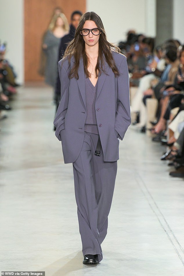 A model wore a gray suit and sweater on the runway