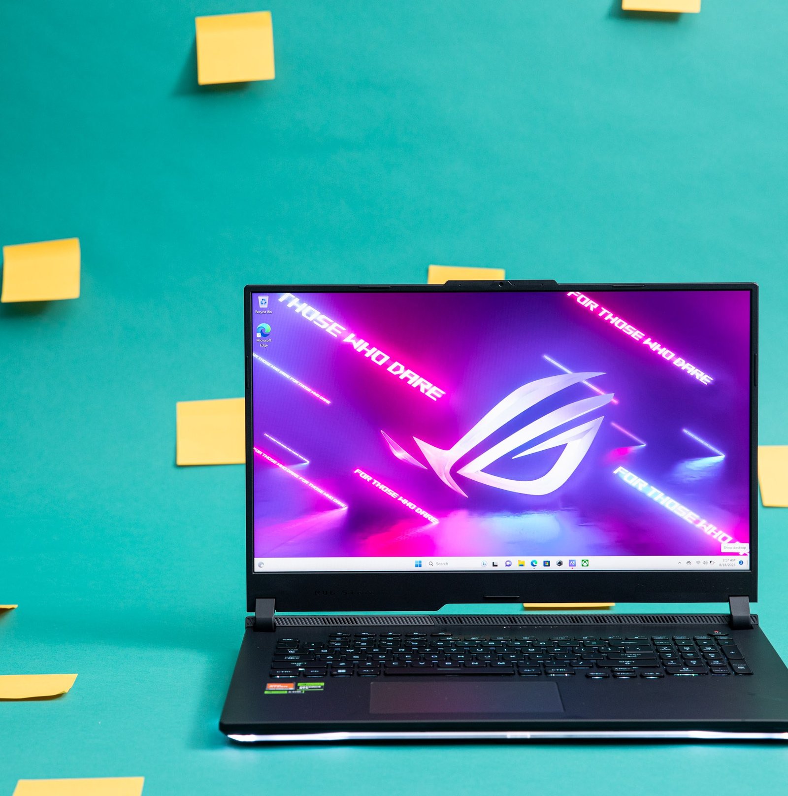 The Asus ROG Strix Scar X3D on a green background decorated with yellow Post-it notes.